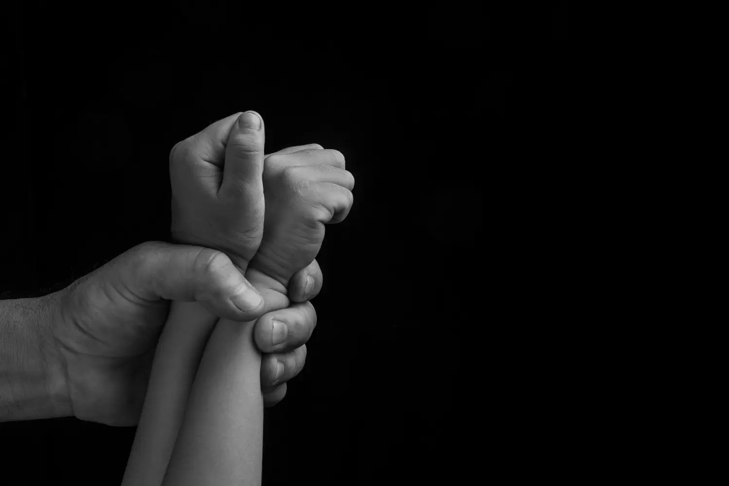 Mann hält Kinderhände fest, Menschenhandel, Ende der Gewalt gegen Kinder.
